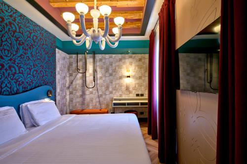 a bedroom with a large bed and a chandelier at Hotel Ca' D'Oro - WENICE Deep Culture in Venice