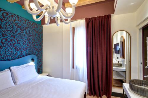 a bedroom with a bed and a chandelier at Hotel Ca' D'Oro - WENICE Deep Culture in Venice