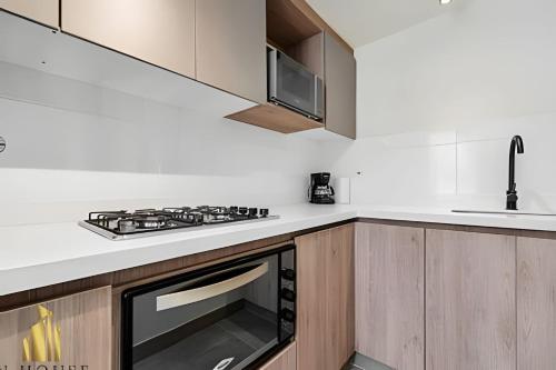 El PobladoにあるCasa Solei 12-9 - Stylish Apt with Jacuzzi & ACのコンロとシンクのある白いキッチン