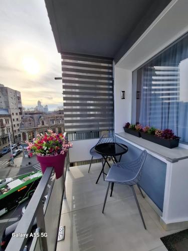 a balcony with two chairs and a table on a building at La Dolce Casa & City Center I Balcony I Netflix in Bucharest