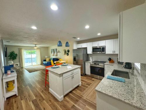 a kitchen and living room with white cabinets at NEW - Amazing Sunshine - Up 6 Guests-Private Backyard in Port Orange