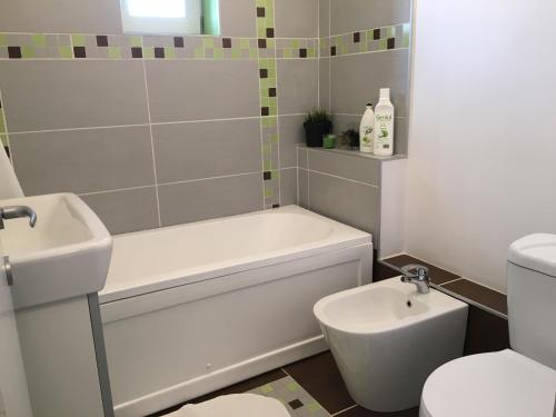 a bathroom with a tub and a toilet and a sink at New Central Roof top view in Bucharest