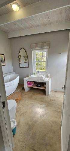 a bathroom with a tub and a sink and a toilet at Inhoek farm Arniston in Arniston