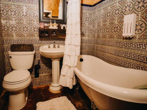 a bathroom with a toilet and a tub and a sink at Hacienda Siesta Alegre in Rio Grande