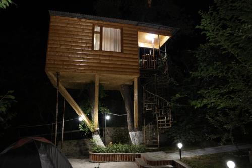 a tree house with a staircase in the night at Tree House & Camping Goris in Goris