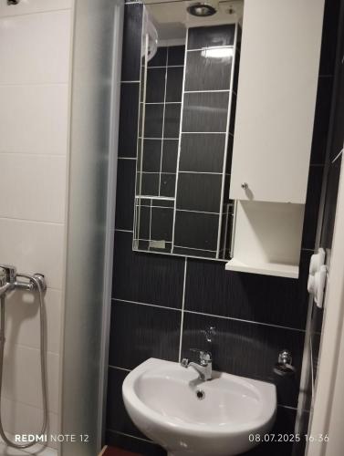 un baño con lavabo y espejo en Hostel Lux, en Bitola