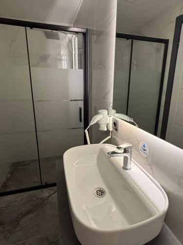 a bathroom with a white sink and a mirror at The Pearl Airport Hotel in Arnavutköy