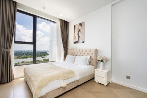 a bedroom with a large bed with a large window at Lumiere Riverside Heera Stay Apartment in Ho Chi Minh City