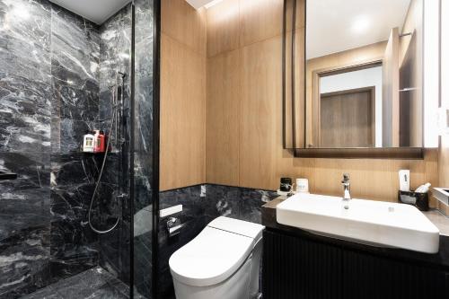 a bathroom with a toilet and a sink and a shower at Lumiere Riverside Heera Stay Apartment in Ho Chi Minh City