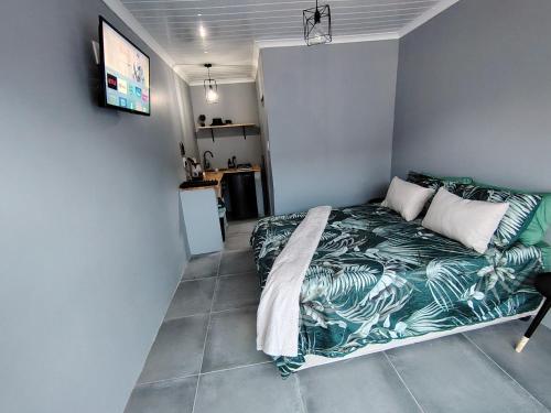 a small bedroom with a bed with a green blanket at 284 On Circular 4 in Gqeberha