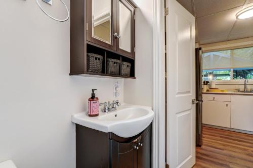 ein Badezimmer mit weißem Waschbecken und eine Küche in der Unterkunft The Cozy Shore Cottage - Large in Wasaga Beach