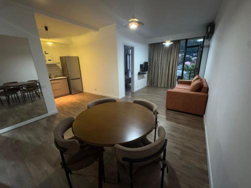 Una sala de estar con mesa y sillas y una cocina. en Guest 19, en Kutaisi