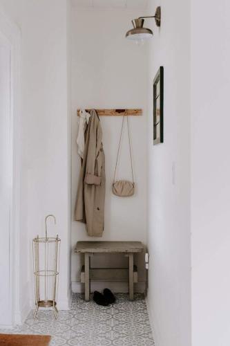 a hallway with a bench and a coat hanging on a wall at The Wild Rose - Cozy PEC Rental in Picton in Picton