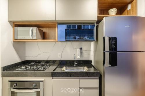a small kitchen with a stainless steel refrigerator at Prédio c/ Aptos Novos a 300m da Praia - EEP in Guarapari