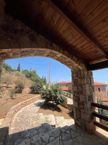 an archway in a stone building with a tree at Konstantina 4 in Ambelókipoi