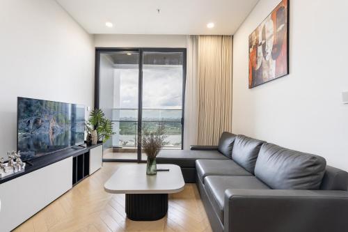 a living room with a couch and a table at Lumiere Riverside Heera Stay Apartment in Ho Chi Minh City