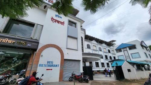 潘达尔普尔Hotel Aishwarya的城市街道上的一座建筑,摩托车停在外面
