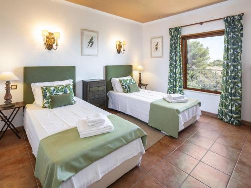 a bedroom with two beds and a window at Stunning Oceanview Algarve Villa 9 Bedrooms Villa Quinta Marinha Amazing Location Overlooking Sea & Huge Pool Benagil in Lagoa