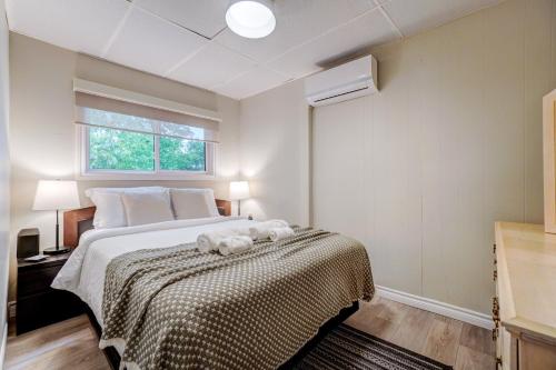 a bedroom with a bed and a window at The Beach House - Steps To Beach Area 3 4br in Wasaga Beach