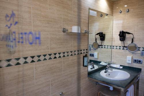 a bathroom with a sink and a mirror at Hotel Flamingo in L'Ampolla