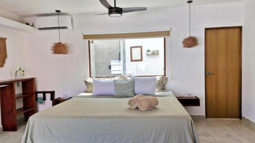 カンクンにあるComfortable studio with pool in the best locationのぬいぐるみが置かれたベッドのある寝室