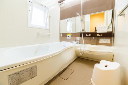 La salle de bains est pourvue d'une baignoire, de toilettes et d'un lavabo. dans l'établissement K's House Kyoto -Travelers Hostel, à Kyoto