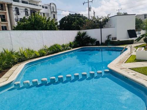 a large blue swimming pool with a white fence at Comfortable studio with pool in the best location in Cancún