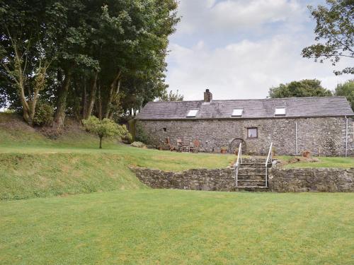 an old stone building with a staircase in front of it at Ty Christian in Blaencelyn