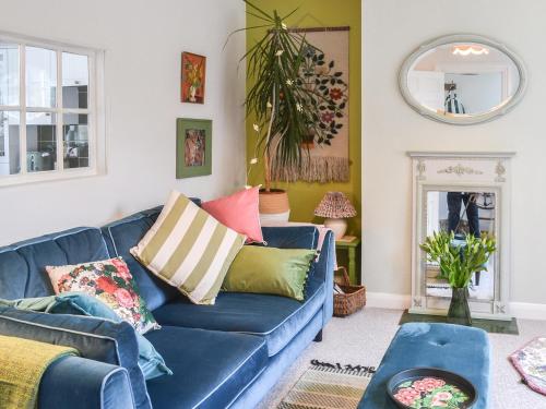 a blue couch with colorful pillows in a living room at Cooper's Cottage in Louth