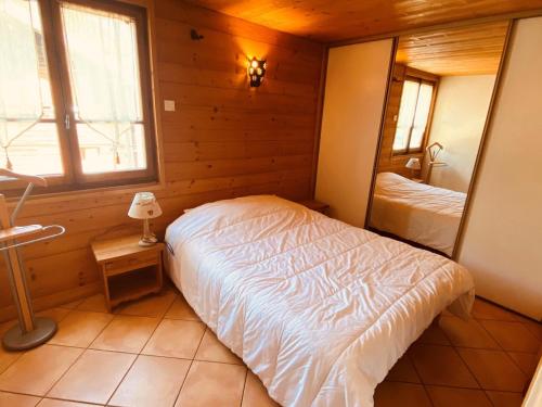 une chambre avec un lit dans une pièce en bois dans l'établissement Appartement 3 pièces avec balcon et Wifi au centre de La Clusaz - FR-1-459-20, à La Clusaz