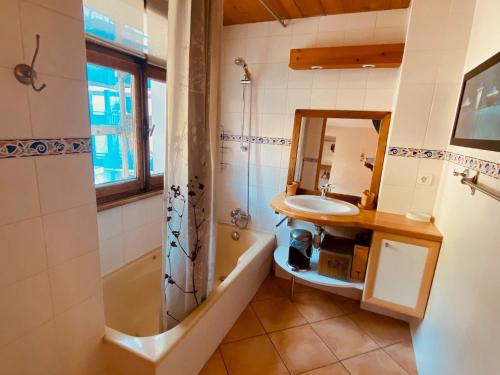 une salle de bain avec un lavabo, une baignoire et un miroir dans l'établissement Appartement 3 pièces avec balcon et Wifi au centre de La Clusaz - FR-1-459-20, à La Clusaz