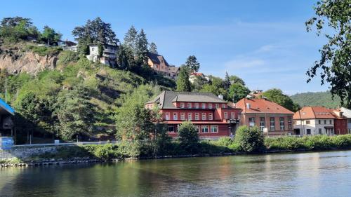 a town on a hill next to a river at Hotel V Pivovaře Davle in Davle