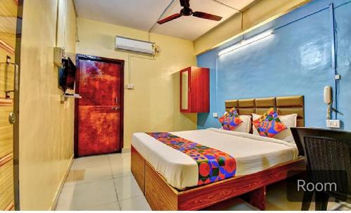 a bedroom with a bed and a red door at srh inn in Jāmb