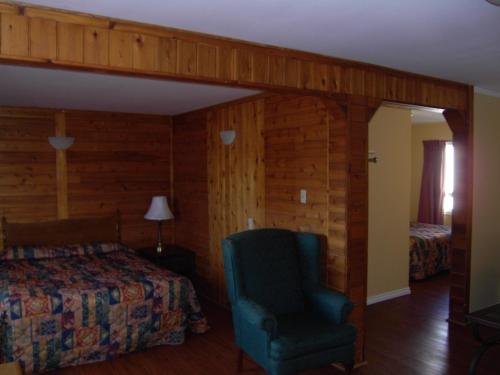 a bedroom with a bed and a chair in a room at Virden Motel in Virden