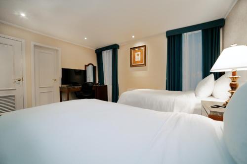 a hotel room with two beds and a television at Hotel Stanford in New York