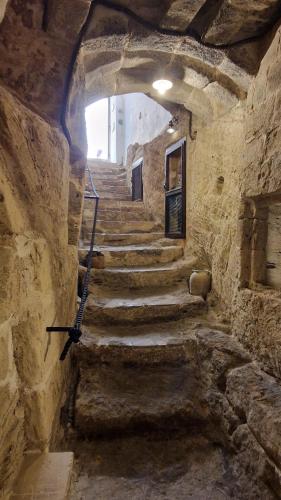 a stone hallway with stairs in a stone building at CASA ELAIO - immersa negli ulivi con vista sul mare Ionio in Marina San Gregorio