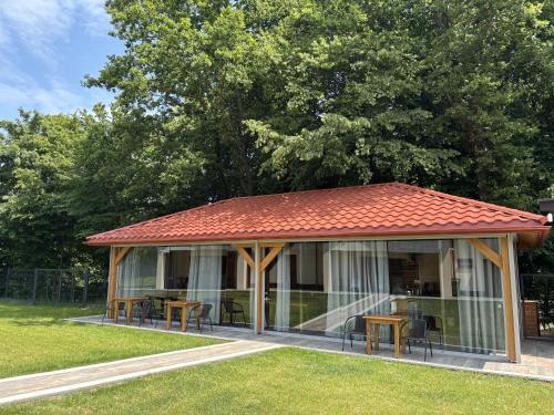 a gazebo with tables and chairs in a park at Apartamenty pod Dębami - noclegi Beskid Niski in Odrzechowa
