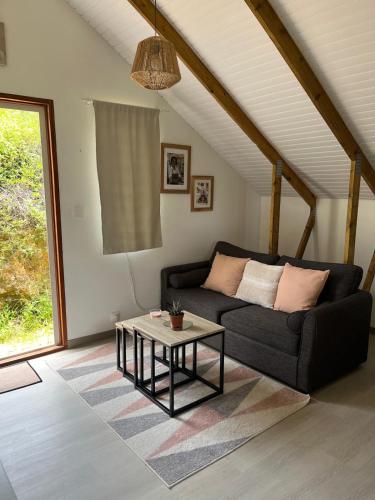 a living room with a couch and a table at Bungalow " Man Doudou" in Les Abymes