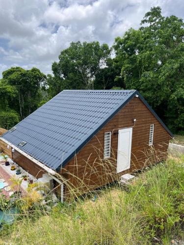 a small house with a solar roof on a field at Bungalow " Man Doudou" in Les Abymes