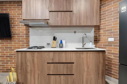 a kitchen with a sink and a brick wall at Kyux 408 - The hidden gem of Laureles in Alpujarra