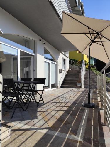 a patio with a table and an umbrella at Maison 40 in Albiano