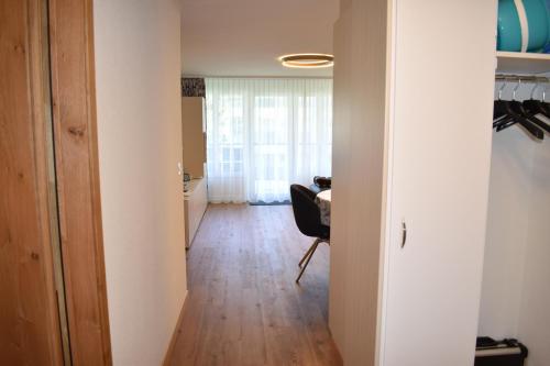 a hallway with a table and a chair in a room at Sotmirana 53 (316 Sh) in Lenzerheide