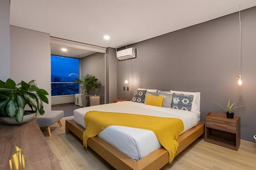 een slaapkamer met een groot bed met een gele deken bij Life 1603 - Panoramic & Tastefully Decorated Loft in El Poblado