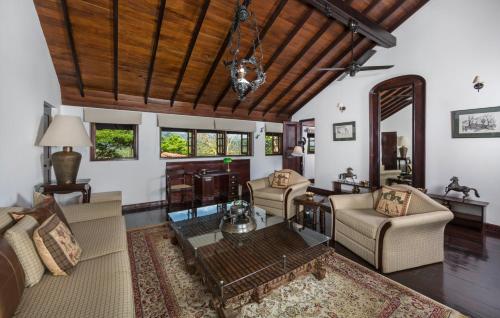 a living room filled with furniture and a wooden ceiling at Clingendael Hotel in Digana