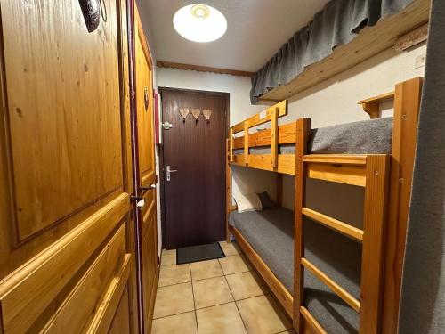 Cette petite chambre comprend des lits superposés et une porte. dans l'établissement Charmant studio rénové proche télécabine avec terrasse et parking - FR-1-642-96, à Morillon