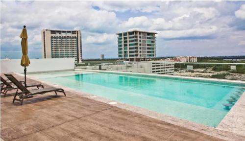 a swimming pool on the roof of a building at Apartment with a view of the lagoon and pool in Cancún