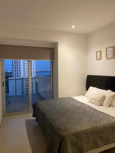 a bedroom with a large bed and a balcony at Apartment with a view of the lagoon and pool in Cancún