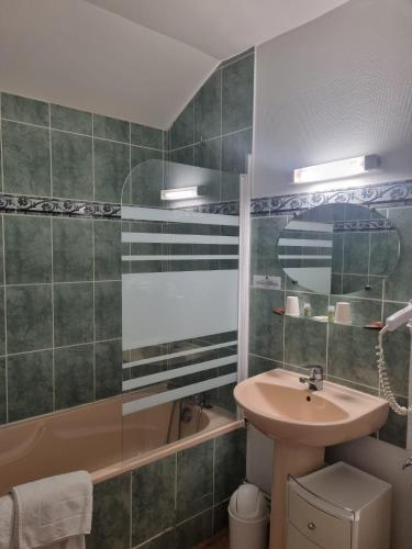une salle de bain avec un lavabo et une baignoire dans l'établissement Auberge de la Forêt, à Le Nouvion-en-Thiérache