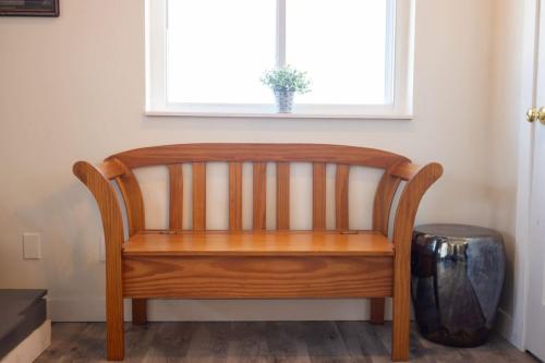 a wooden bench in a room with a window at Views of Lone Peak and mini golf in Draper