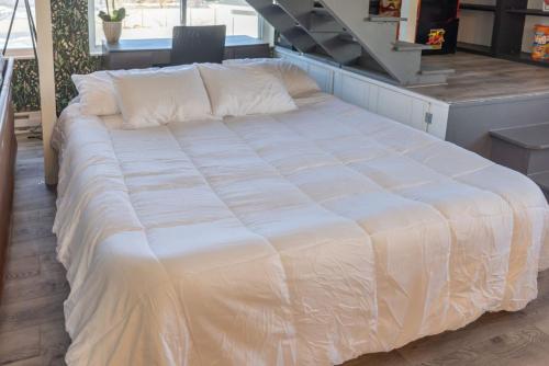a large white bed in a room with a staircase at Views of Lone Peak and mini golf in Draper